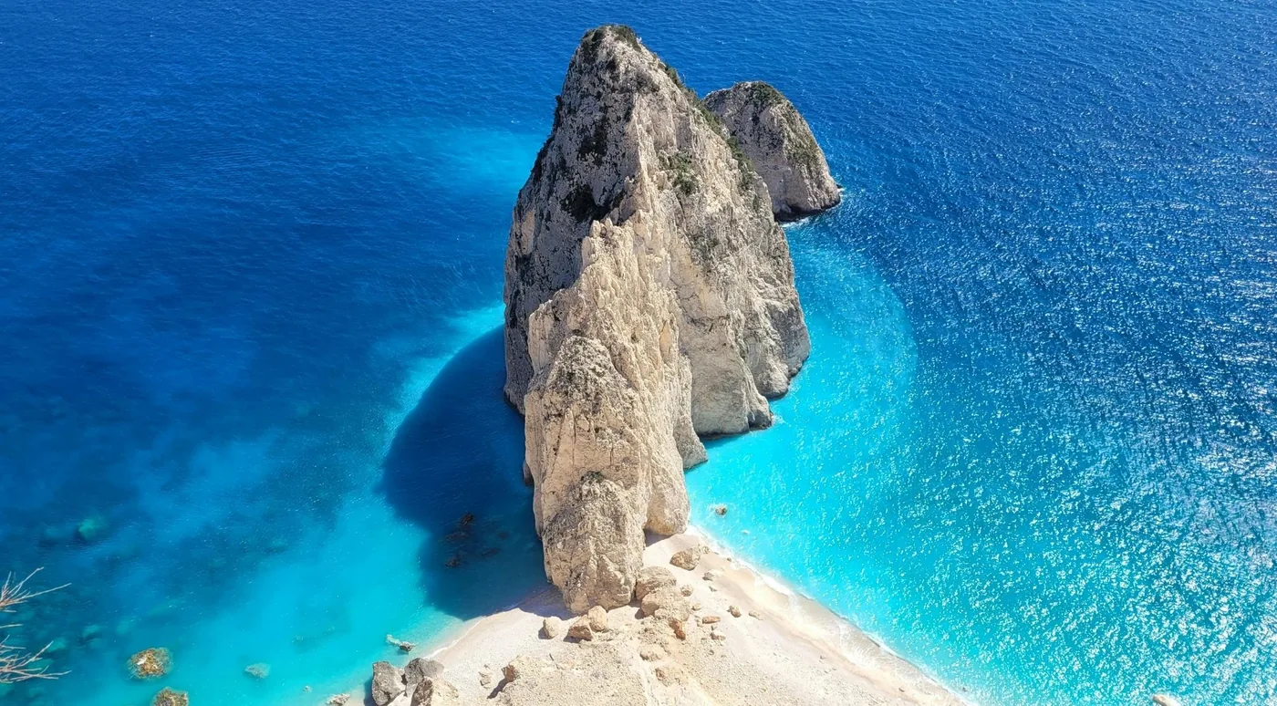 Aerial view of the Mizithres sea stacks rising from turquoise water off Cape Keri