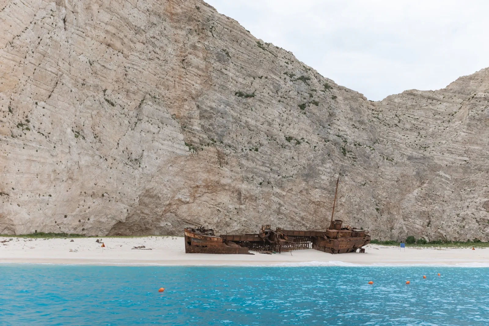 The Panagiotis wreck on the sand beneath white cliffs, seen from the boat