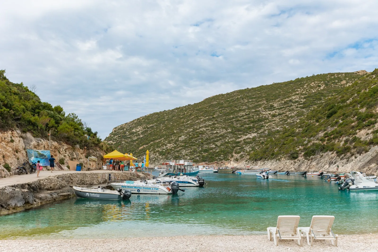 Boats at the Porto Vromi Maries quay with the small beach and cafe behind