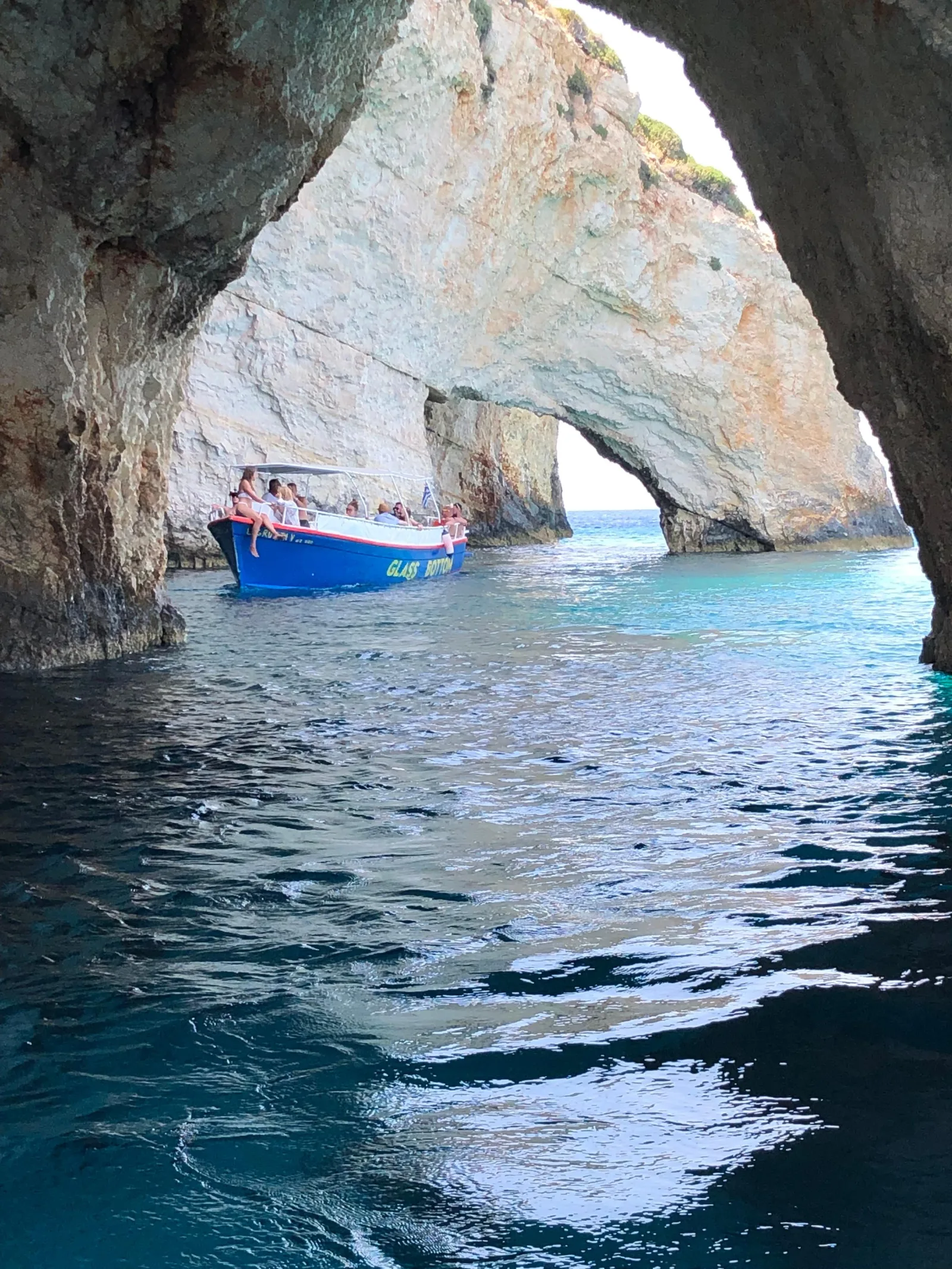 Looking out through a Blue Caves arch to the sea and a passing boat
