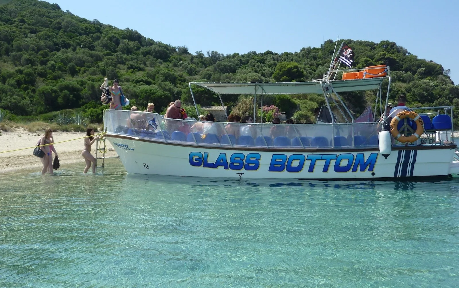 The glass-bottom boat at the beach on Marathonisi with passengers wading ashore