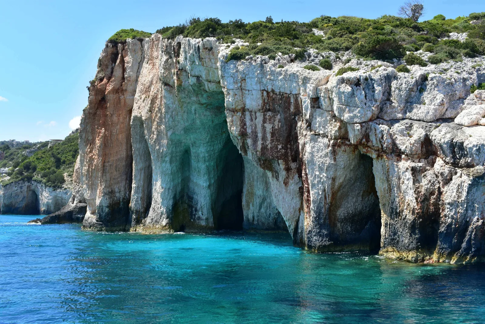 Rows of arches and cave openings at the Blue Caves seen from the water
