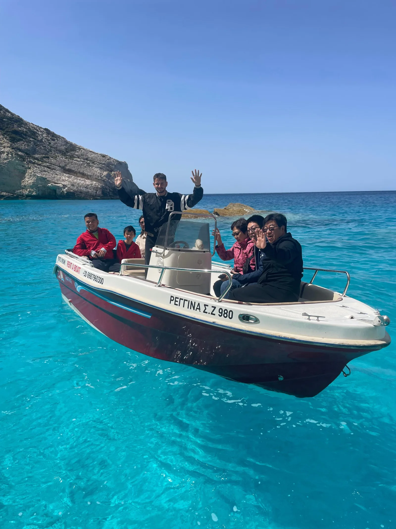 A family on a rental speedboat off the Porto Vromi cliffs