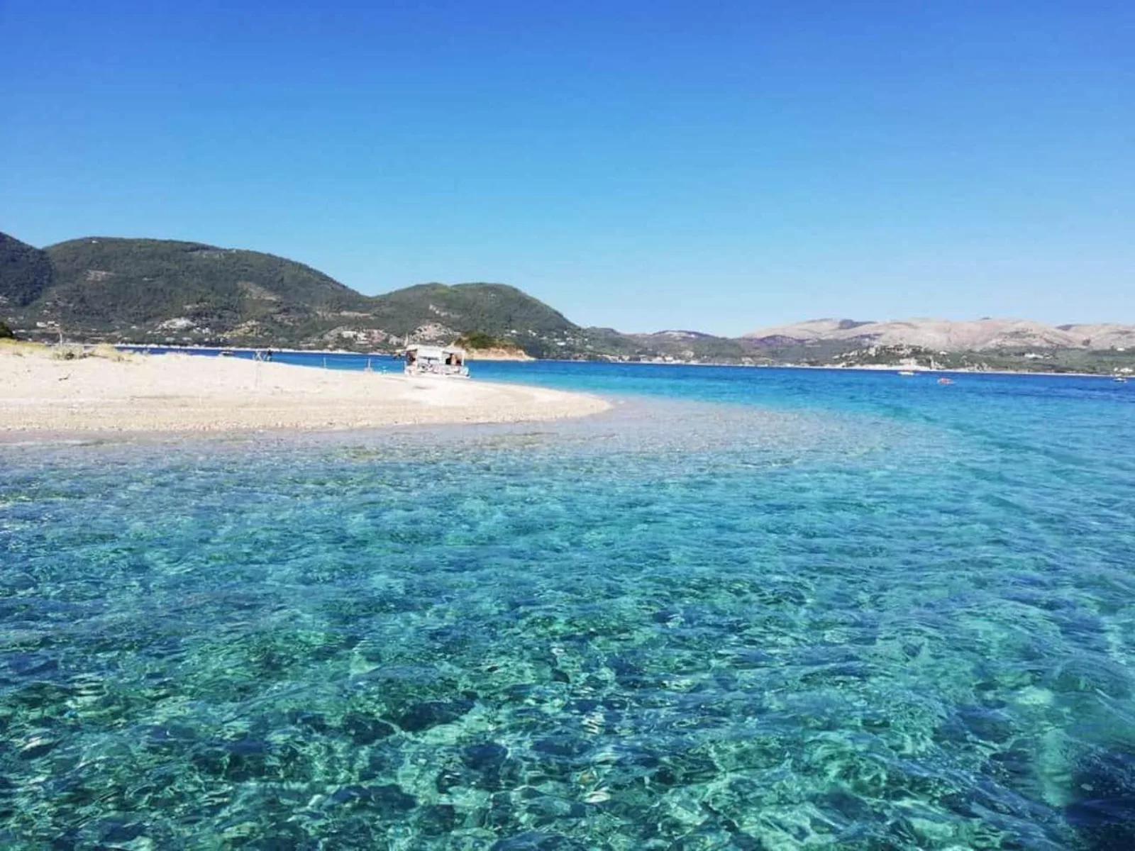 The sand bar on Marathonisi with a boat moored in the shallows