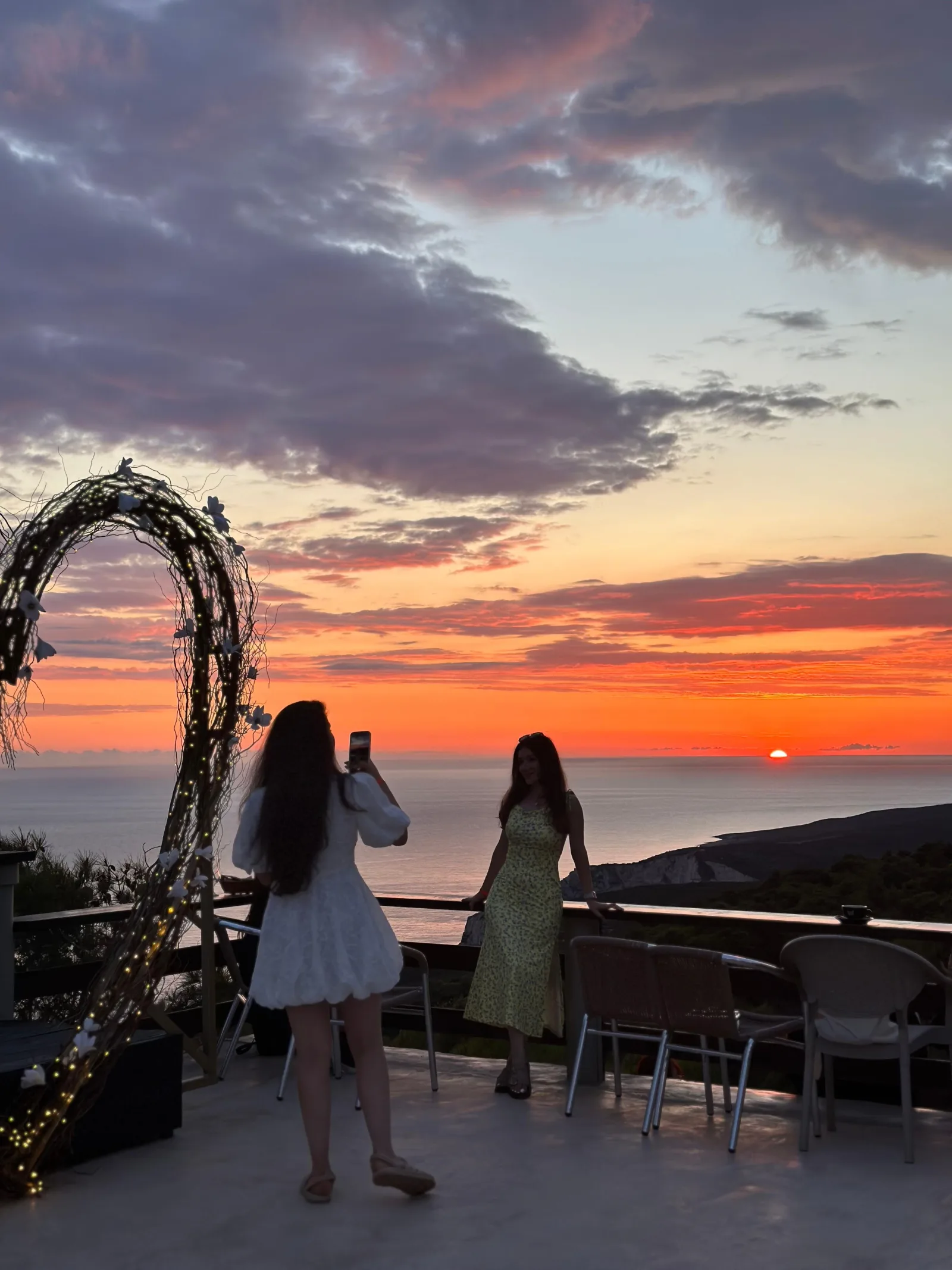 Two women photographing the sunset from the terrace at Agalas