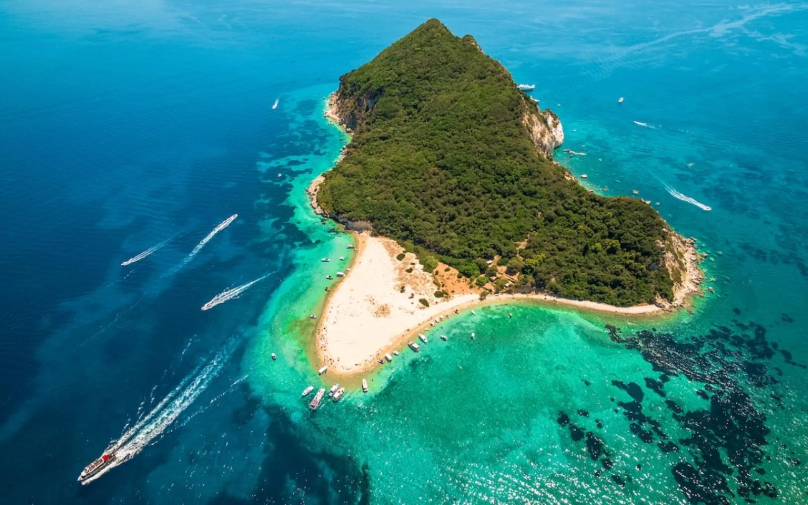 Aerial view of Marathonisi with boats anchored off its beach