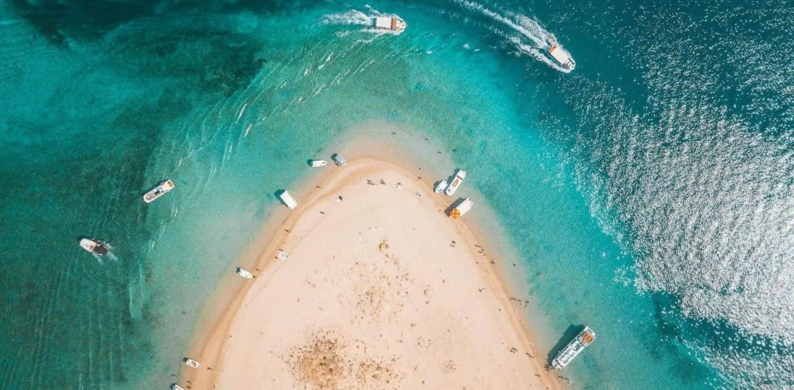 Aerial view of the sand spit of Marathonisi, Turtle Island, with boats anchored around it