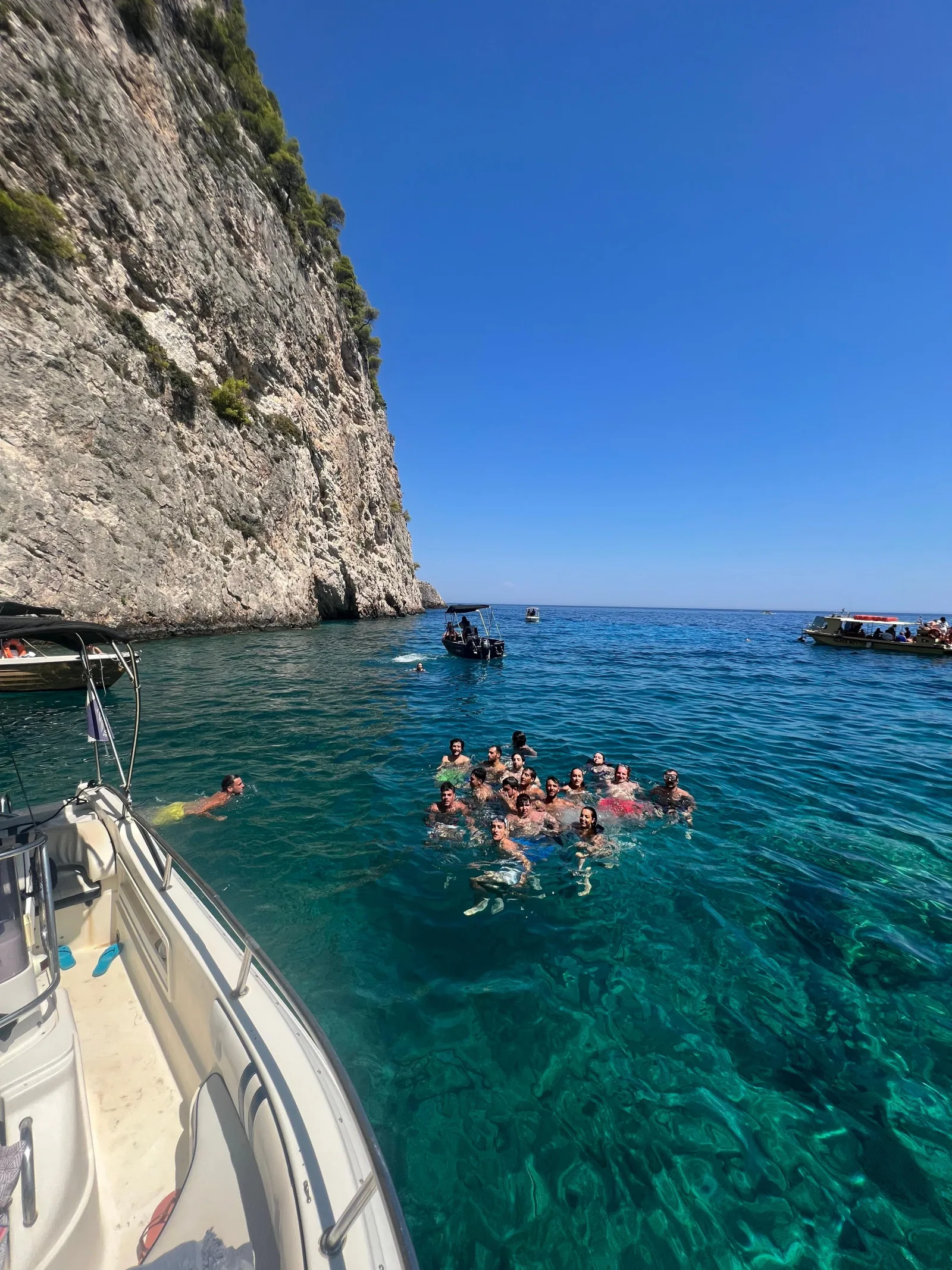Swimmers off the speedboat below the white cliffs of Cape Keri